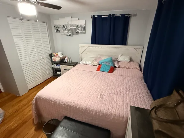 a bedroom with a bed and a mirror on the dresser