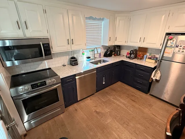 a kitchen with stainless steel appliances granite countertop a stove a sink and a refrigerator