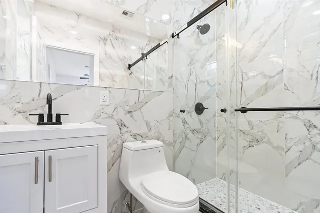 a bathroom with a sink a toilet and shower