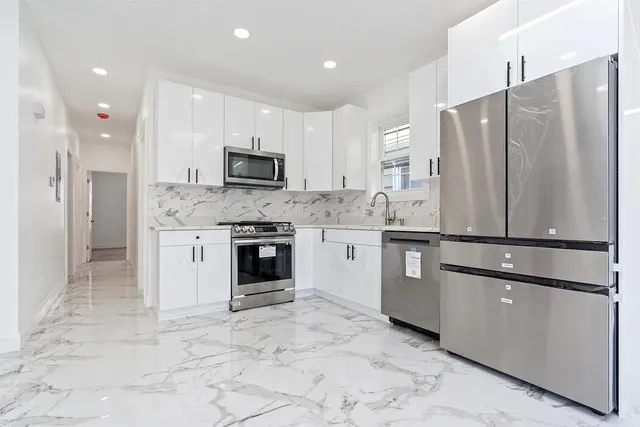 a kitchen with stainless steel appliances granite countertop a refrigerator sink and cabinets