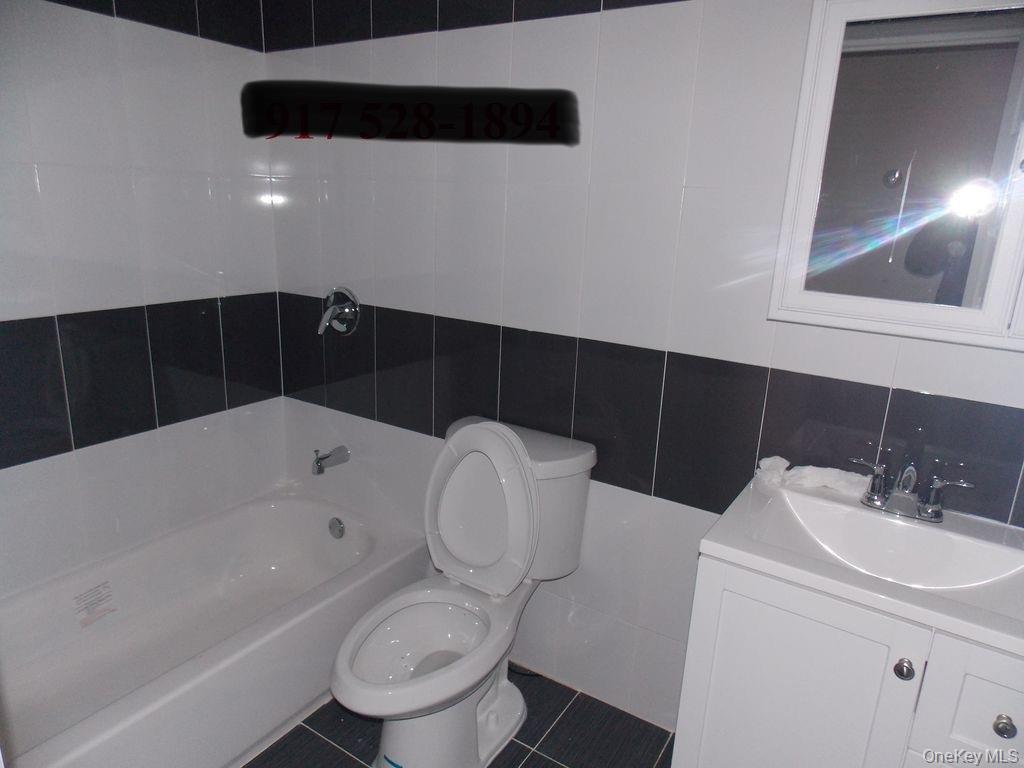 439 Forbell Street Brooklyn, NY 11208 - Photo 4 of 8 a bathroom with a sink a toilet and bathtub