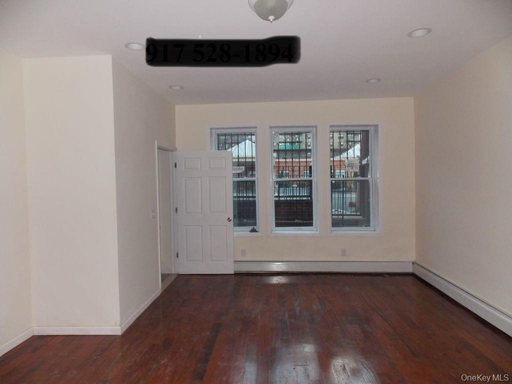 439 Forbell Street Brooklyn, NY 11208 - Photo 7 of 8 an empty room with wooden floor and windows