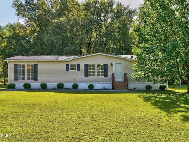 a view of a house with a swimming pool and a yard