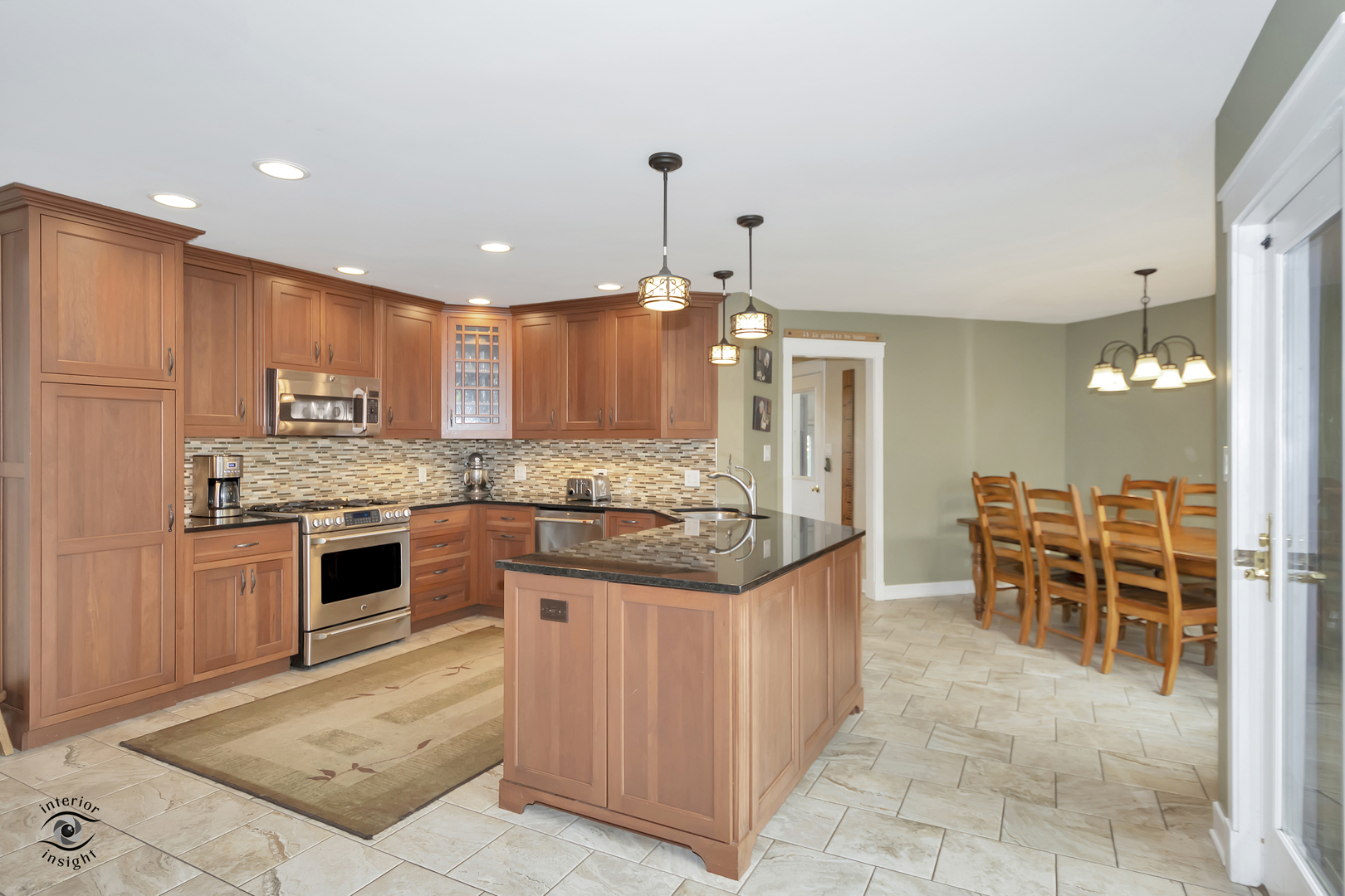 1560 Southhampton Drive Bourbonnais, IL 60914 - Photo 9 of 28 a kitchen with stainless steel appliances kitchen island granite countertop a stove top oven a sink dishwasher a dining table and chairs with wooden floor