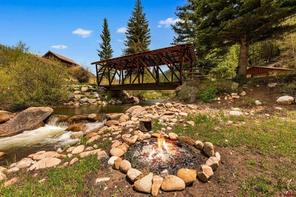 a view of a house with backyard and trees