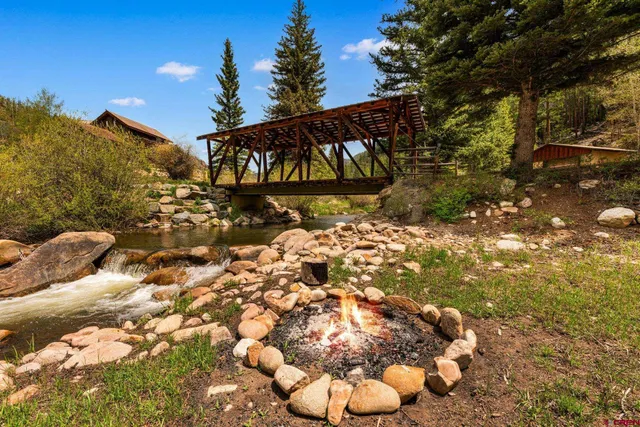 a view of a house with backyard and trees