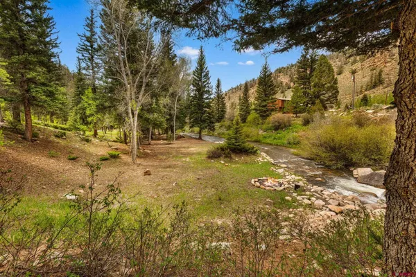 a view of house with backyard and sitting area