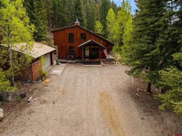 a wooden house with trees in the background