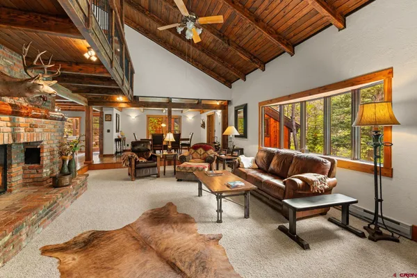 a living room with furniture a flat screen tv and a large window