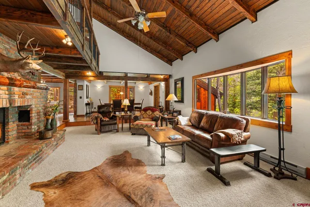 a living room with furniture a flat screen tv and a large window