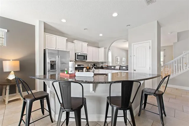 a kitchen with a dining table chairs and white cabinets