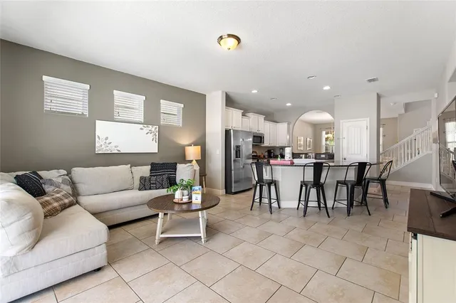 a bedroom with a bed a chair and a potted plant