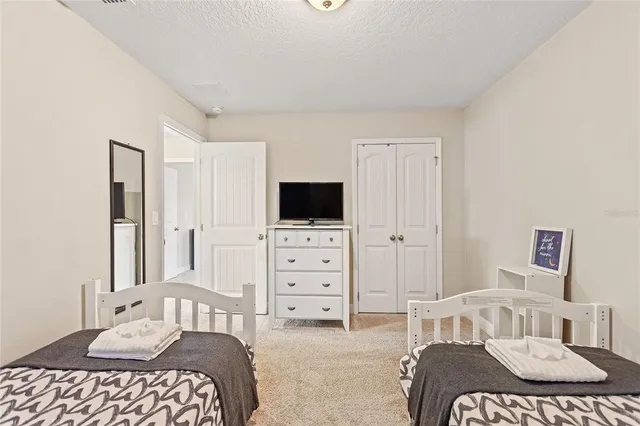 a spacious bedroom with a bed and wooden floor