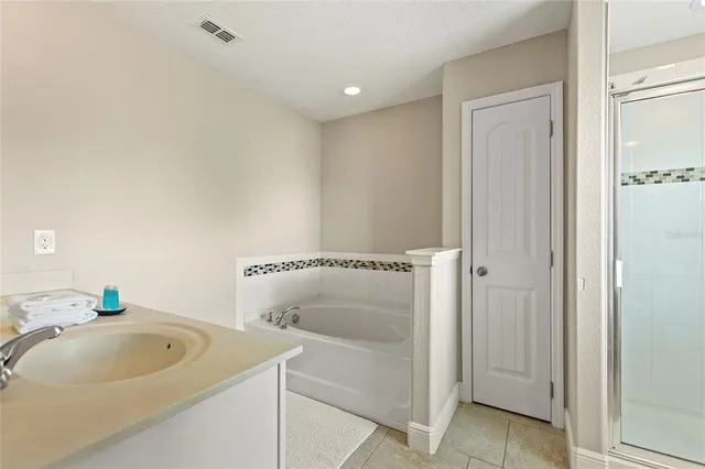 a bathroom with a double vanity sink a mirror and a bathtub