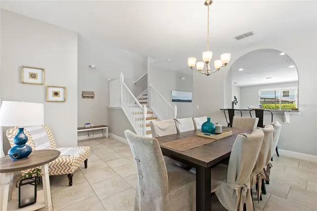 a view of a dining room with furniture a chandelier and wooden floor