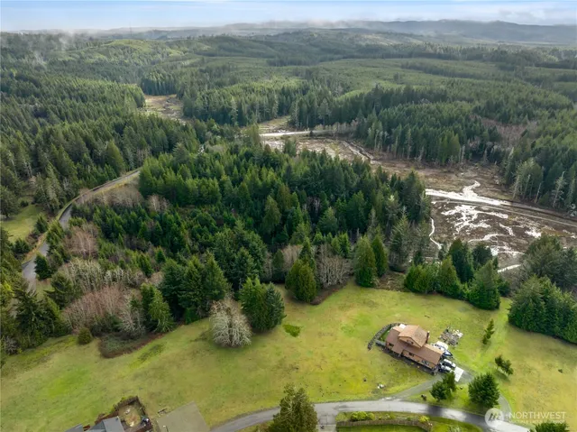 an aerial view of residential house with outdoor space and trees all around