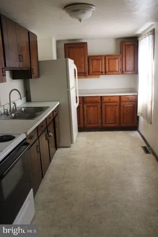 a kitchen with stainless steel appliances a sink stove and refrigerator