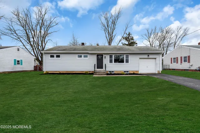 a front view of house with yard and green space