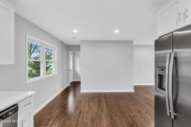 a view of a kitchen with a refrigerator cabinets and wooden floor