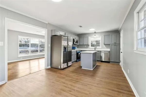 a kitchen with a refrigerator a sink dishwasher with a stove and wooden cabinets