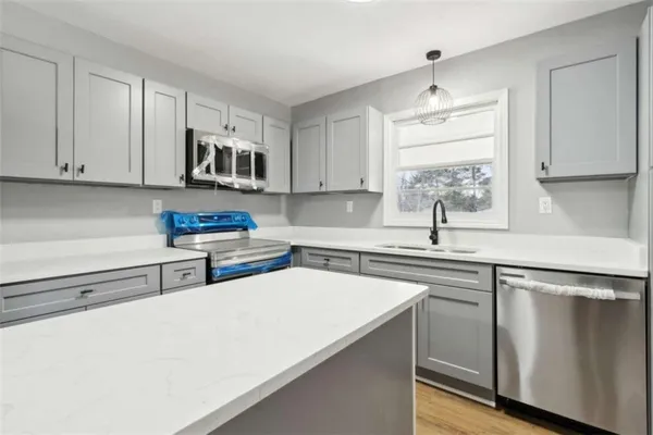 a kitchen with stainless steel appliances a sink a stove and a refrigerator