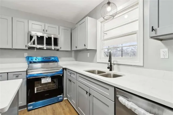 a kitchen with stainless steel appliances granite countertop a sink and a stove