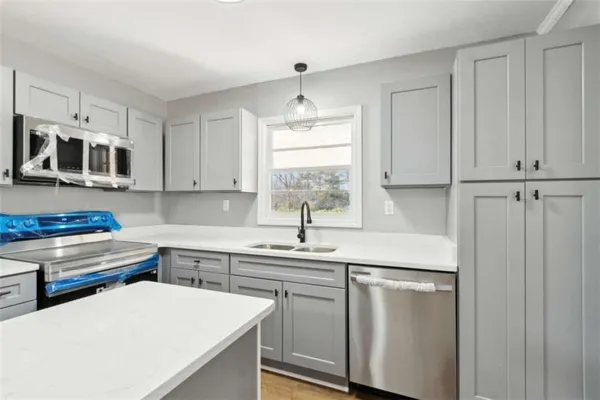 a kitchen with stainless steel appliances a sink a stove a refrigerator and cabinets