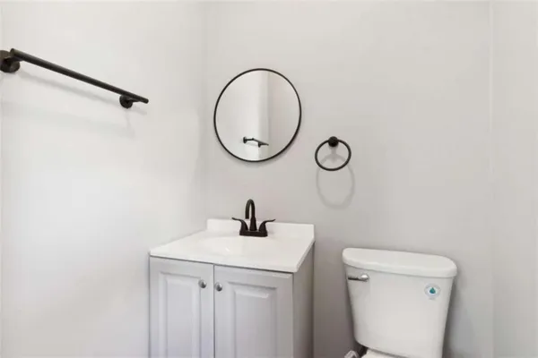 a bathroom with a toilet a sink and a mirror