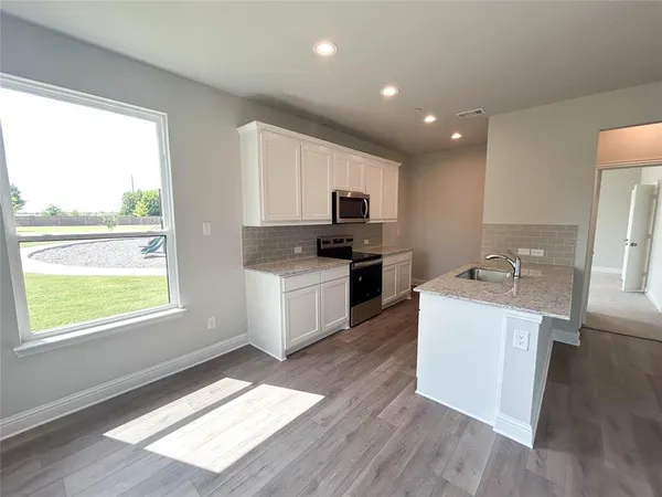 a kitchen with granite countertop a sink and a stove top oven