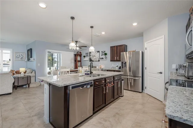 a kitchen with stainless steel appliances kitchen island granite countertop a sink stove and refrigerator