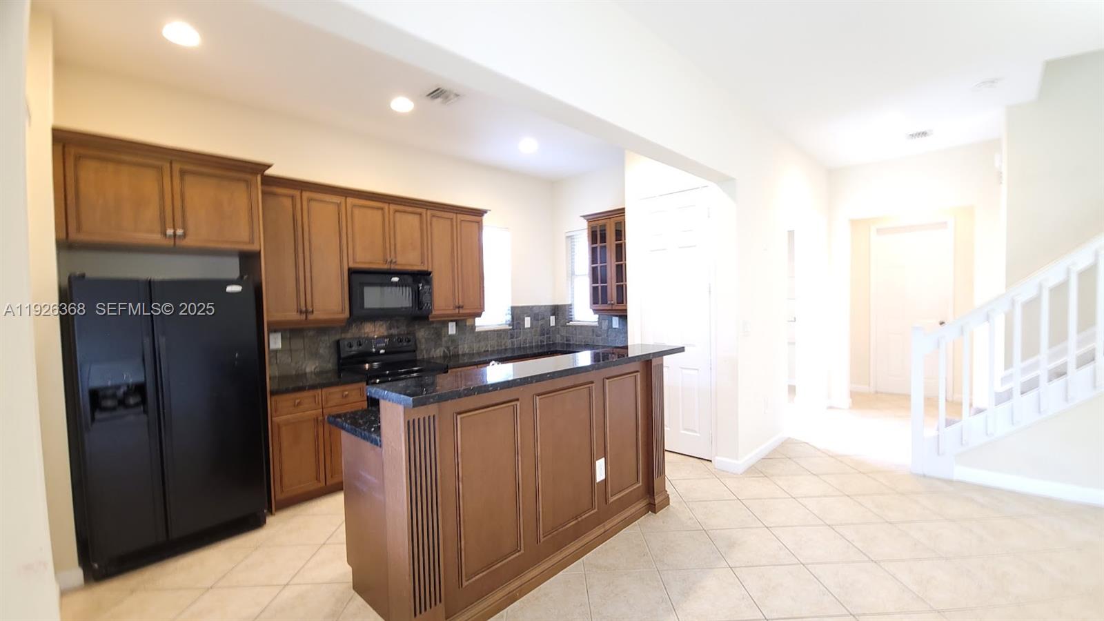 6033 Northwest 118th Drive, Unit 6033 Coral Springs, FL 33076 - Photo 12 of 43 a kitchen with stainless steel appliances granite countertop a refrigerator and a stove top oven