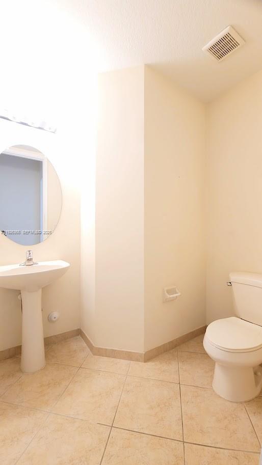 6033 Northwest 118th Drive, Unit 6033 Coral Springs, FL 33076 - Photo 17 of 43 a bathroom with a toilet sink and mirror