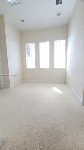 an empty room with windows and bathroom