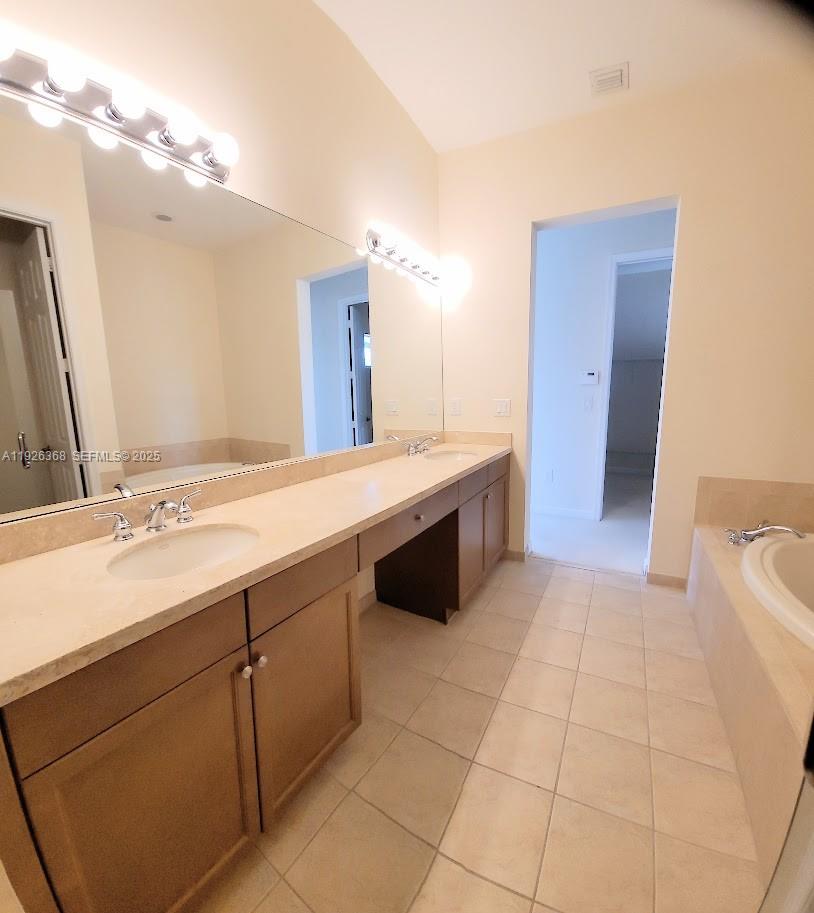 6033 Northwest 118th Drive, Unit 6033 Coral Springs, FL 33076 - Photo 29 of 43 a spacious bathroom with a double vanity sink a mirror and a