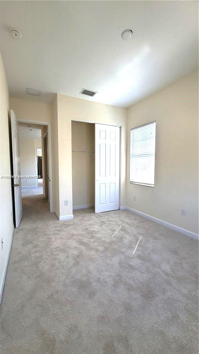 6033 Northwest 118th Drive, Unit 6033 Coral Springs, FL 33076 - Photo 33 of 43 an empty room with windows and a bathroom