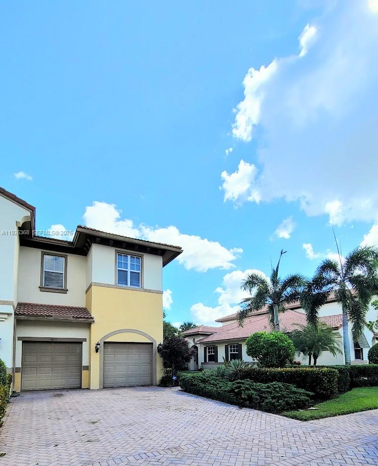 6033 Northwest 118th Drive, Unit 6033 Coral Springs, FL 33076 - Photo 39 of 43 a front view of a house with a yard