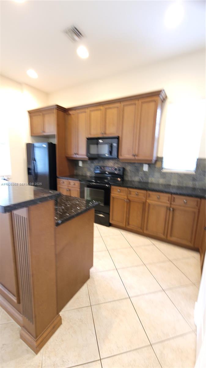 6033 Northwest 118th Drive, Unit 6033 Coral Springs, FL 33076 - Photo 5 of 43 a kitchen with stainless steel appliances granite countertop a stove a sink and a microwave