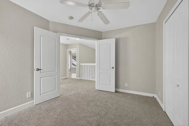 a view of swimming pool with seating area and trees in the background