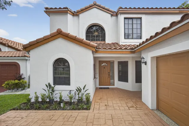 a view of a house with large windows and a small yard