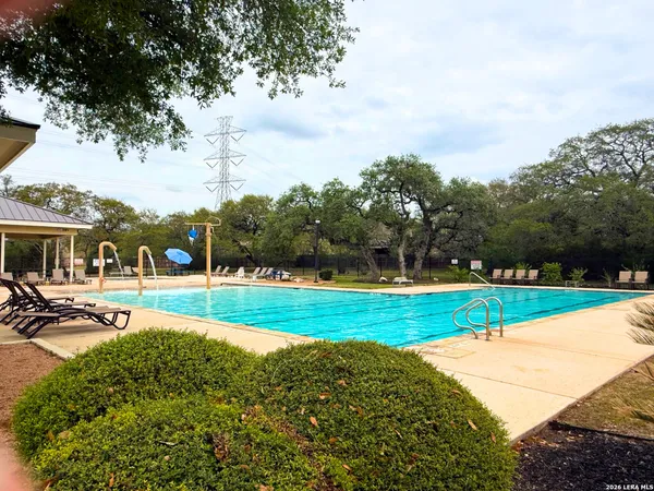 a view of a swimming pool with a yard and sitting area