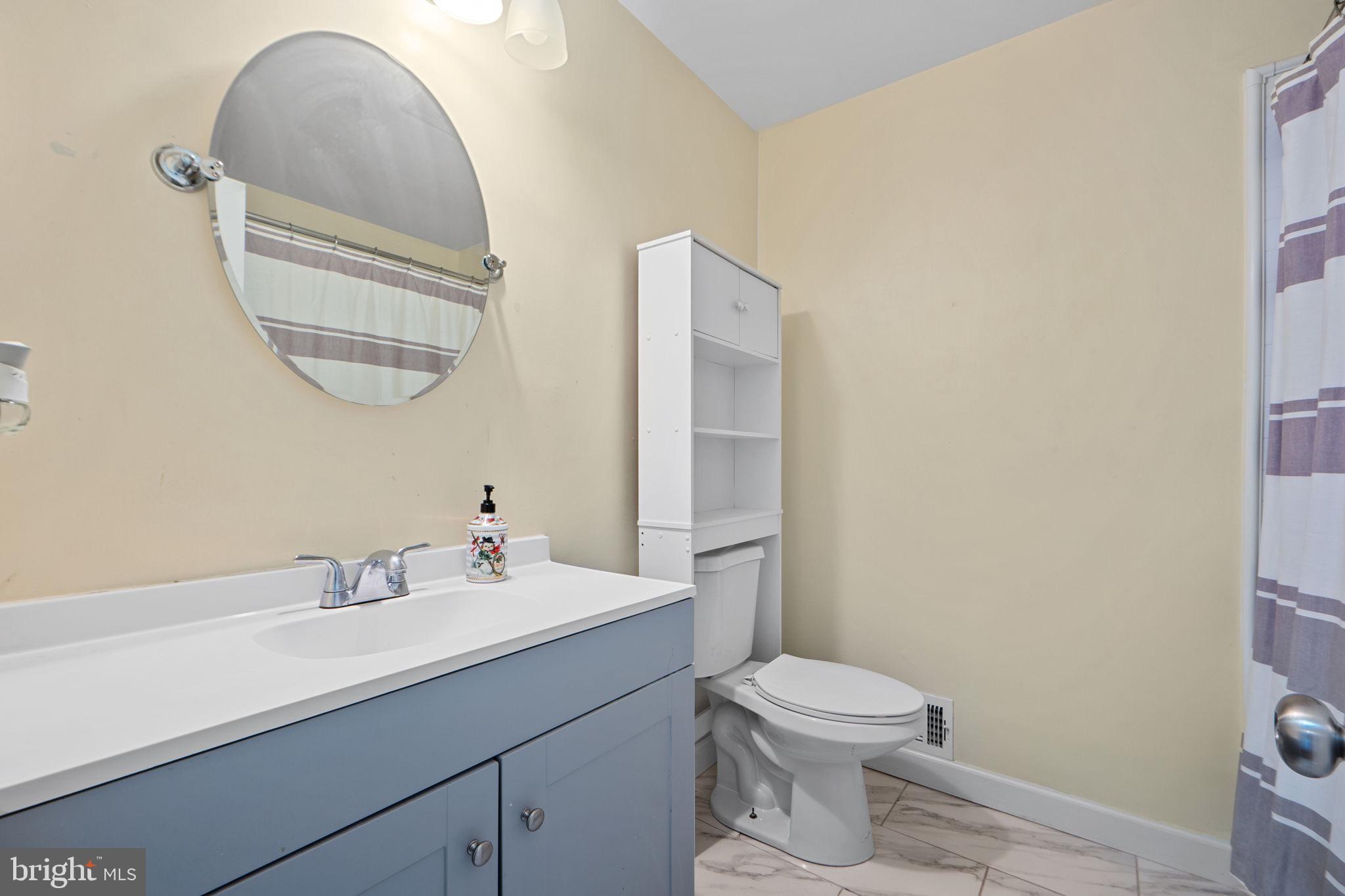 7222 Willow Oak Place Springfield, VA 22153 - Photo 21 of 34 a bathroom with a toilet a sink a mirror and a window