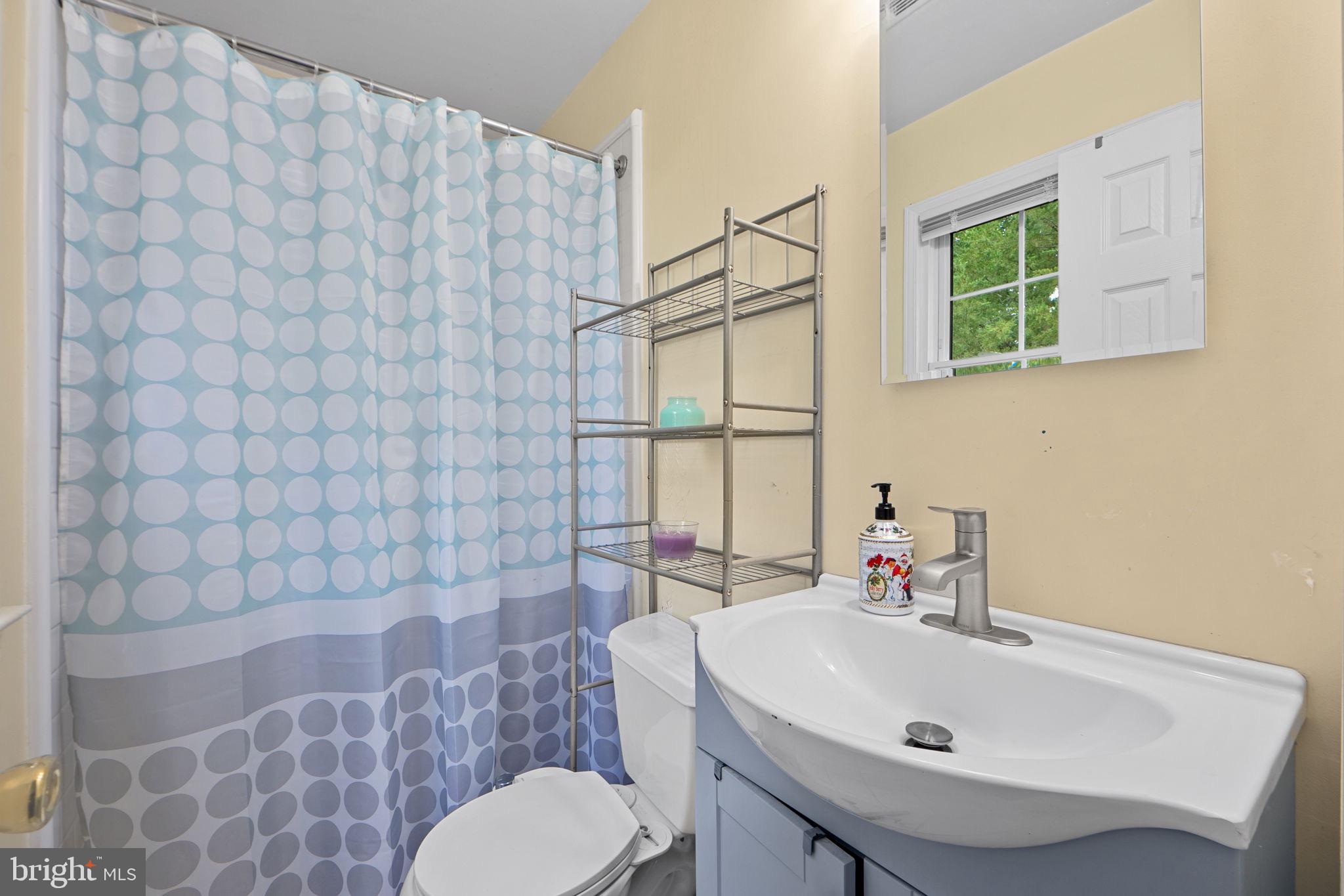 7222 Willow Oak Place Springfield, VA 22153 - Photo 23 of 34 a bathroom with a sink a toilet and shower curtain