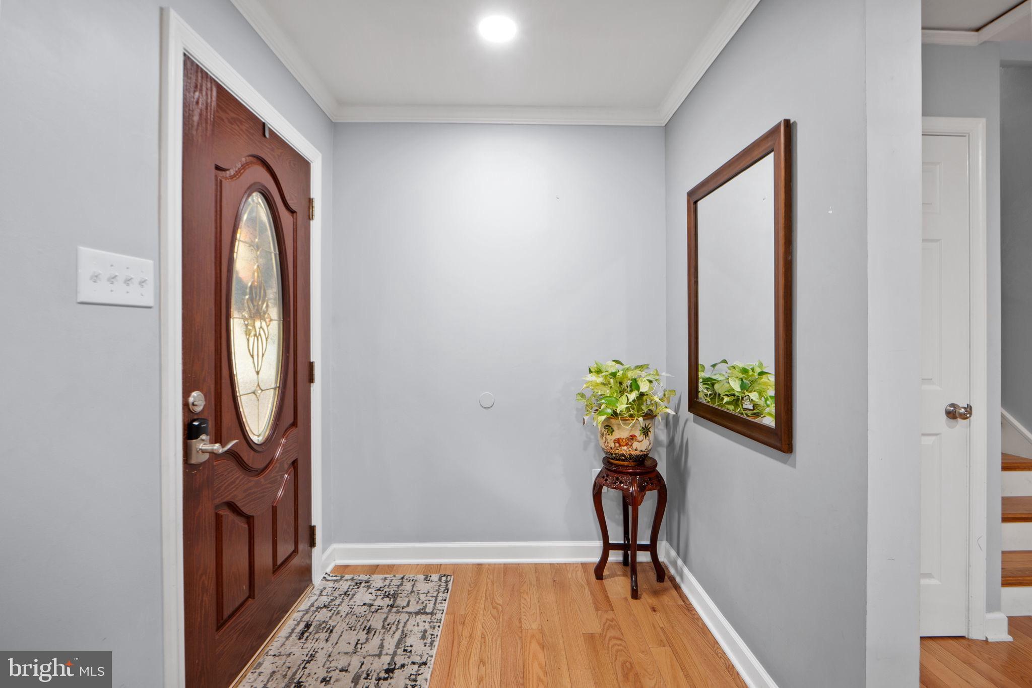 7222 Willow Oak Place Springfield, VA 22153 - Photo 5 of 34 a view of a hallway with wooden floor and a potted plant