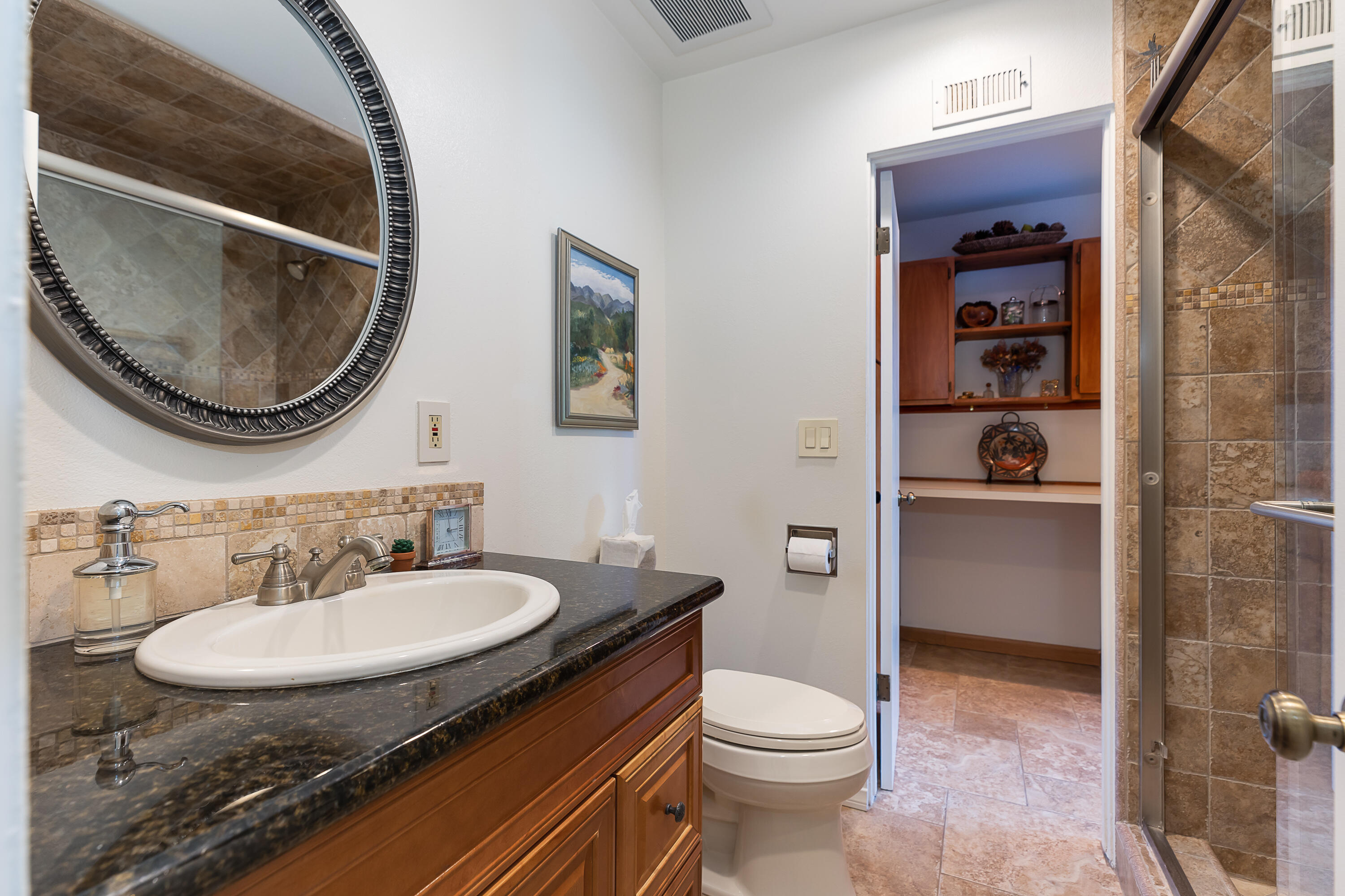 4655 Aragon Drive Carpinteria, CA 93013 - Photo 11 of 32 a bathroom with a granite countertop toilet a sink and a mirror