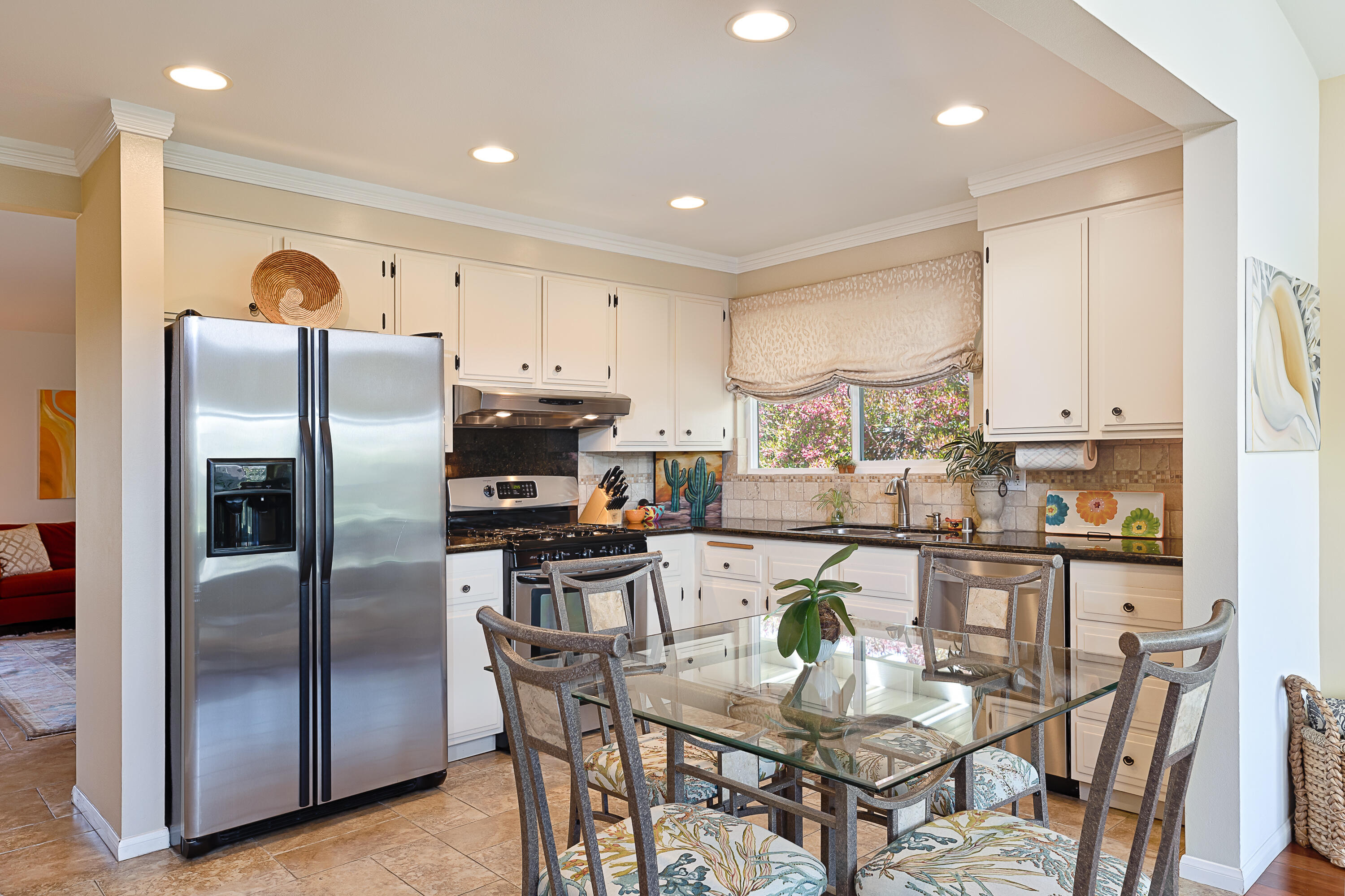 4655 Aragon Drive Carpinteria, CA 93013 - Photo 7 of 32 a kitchen with stainless steel appliances granite countertop a refrigerator a stove a sink a dining table and chairs