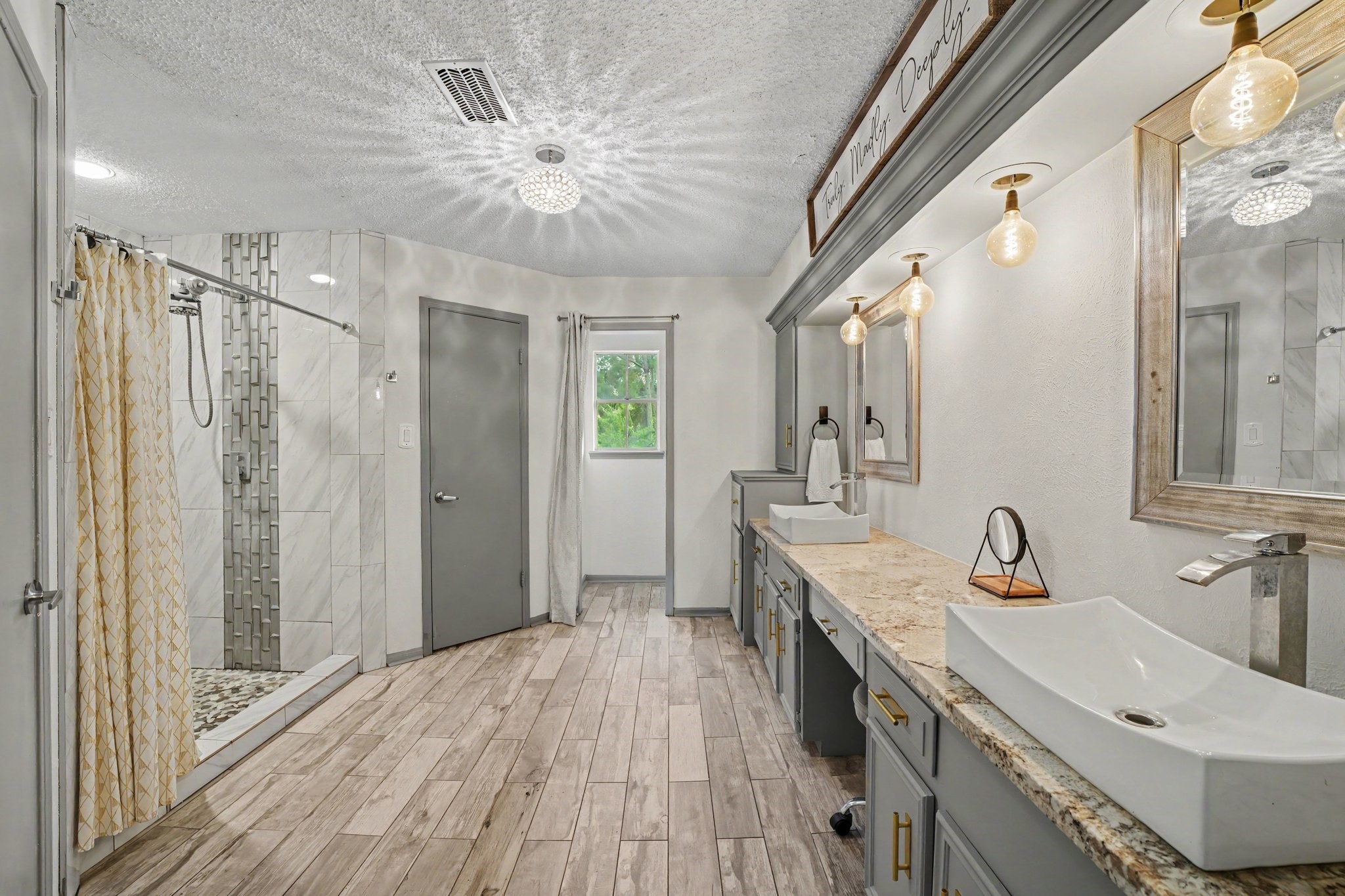 9530 Arcade Drive Spring, TX 77379 - Photo 25 of 32 Lavish primary bathroom showcases dual sinks, ample storage, and vanity seating.