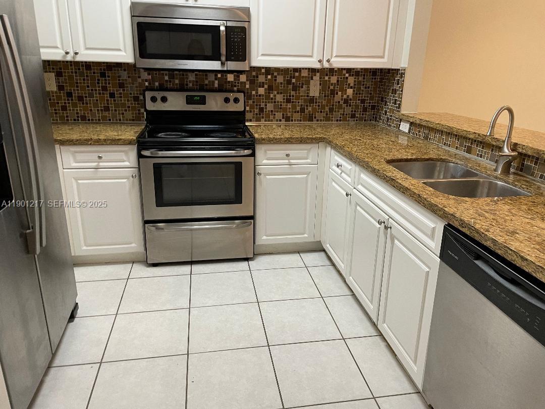 16530 Southwest 96th Terrace Miami, FL 33196 - Photo 6 of 22 a kitchen with cabinets appliances and a sink