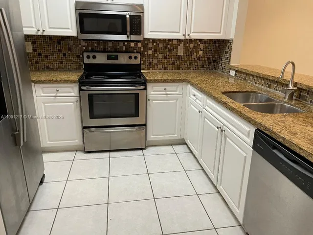 a kitchen with cabinets appliances and a sink