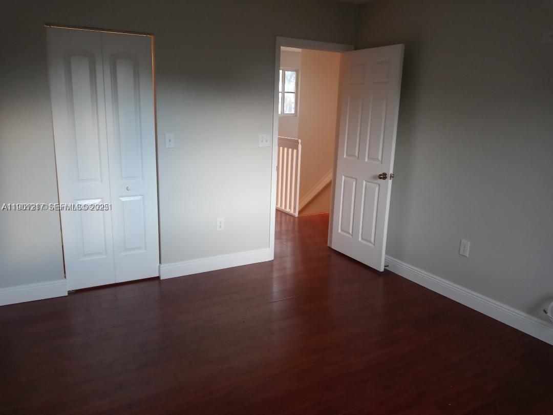 16530 Southwest 96th Terrace Miami, FL 33196 - Photo 9 of 22 an empty room with wooden floor and closet area
