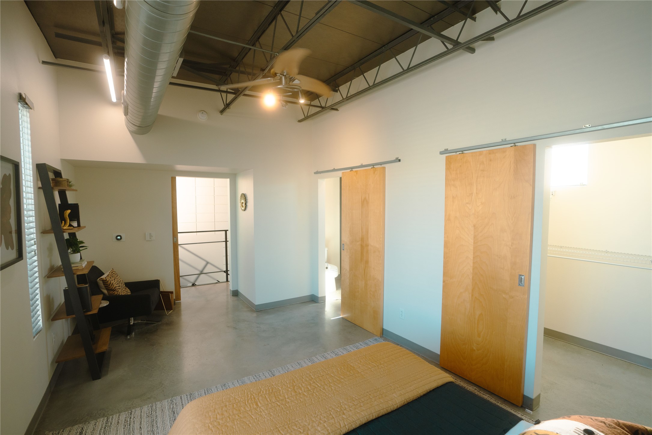 4801 South Congress Avenue, Unit H5 Austin, TX 78745 - Photo 20 of 39 Bedroom featuring concrete flooring, a high ceiling, and a barn door